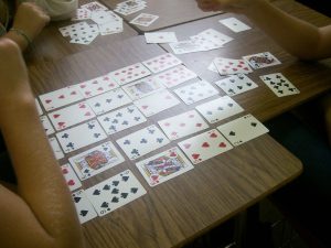 playing cards laying in grid on student desk.