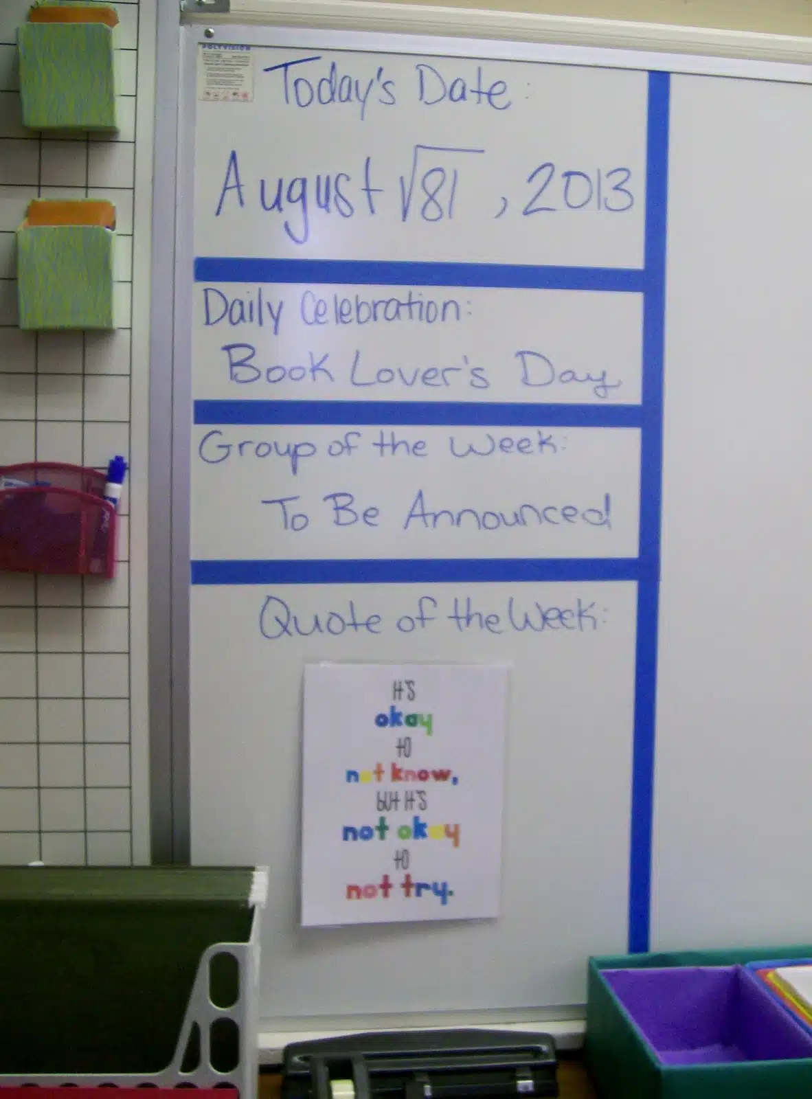 Whiteboard in high school math classroom with date written as a math problem, daily holiday, and quote of the week. 