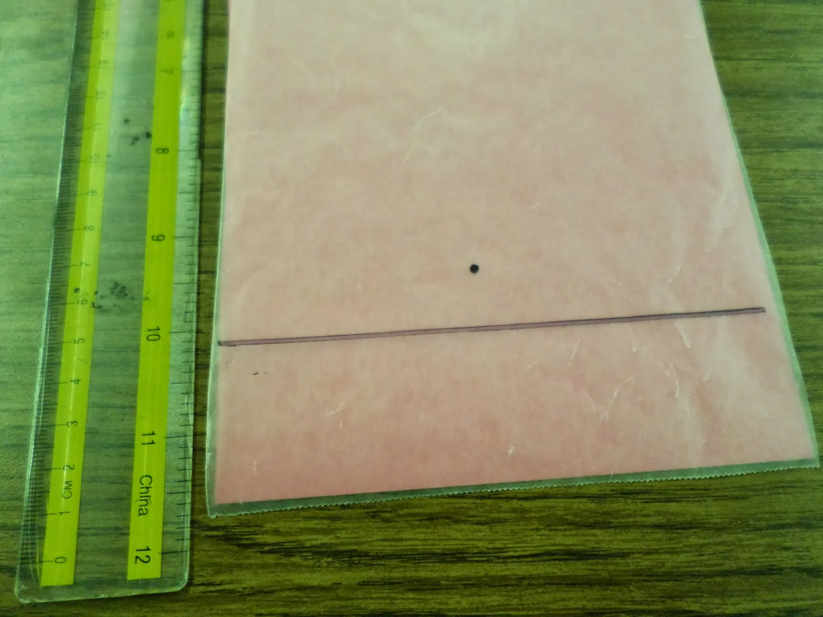 focus dot drawn above horizontal line on wax paper for wax paper parabola activity. 