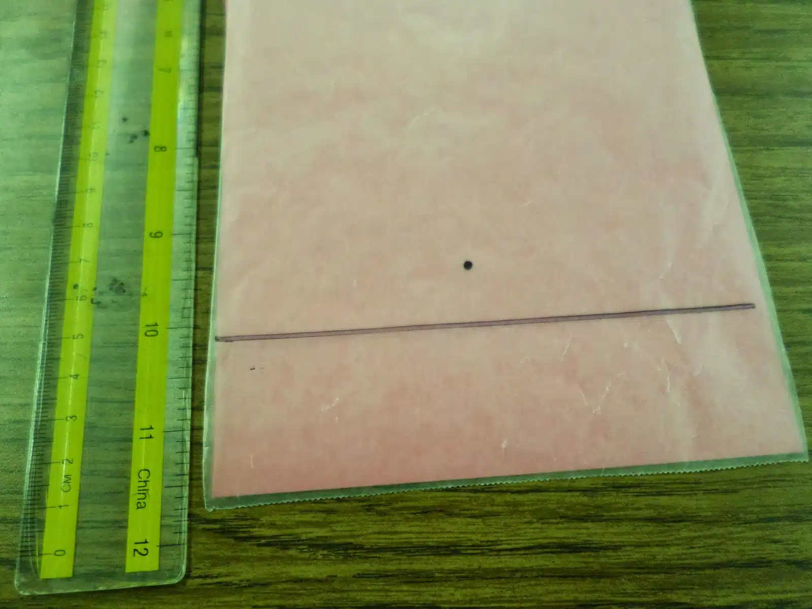 focus dot drawn above horizontal line on wax paper for wax paper parabola activity. 