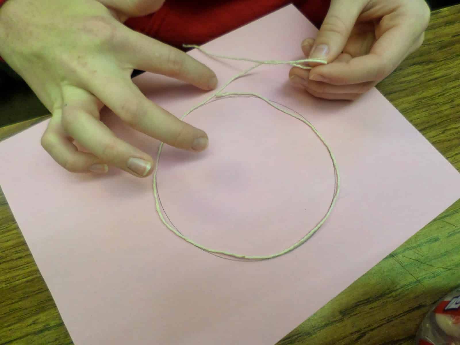 student wrapping string around circle during Cutting Pi Discovery Activity. 