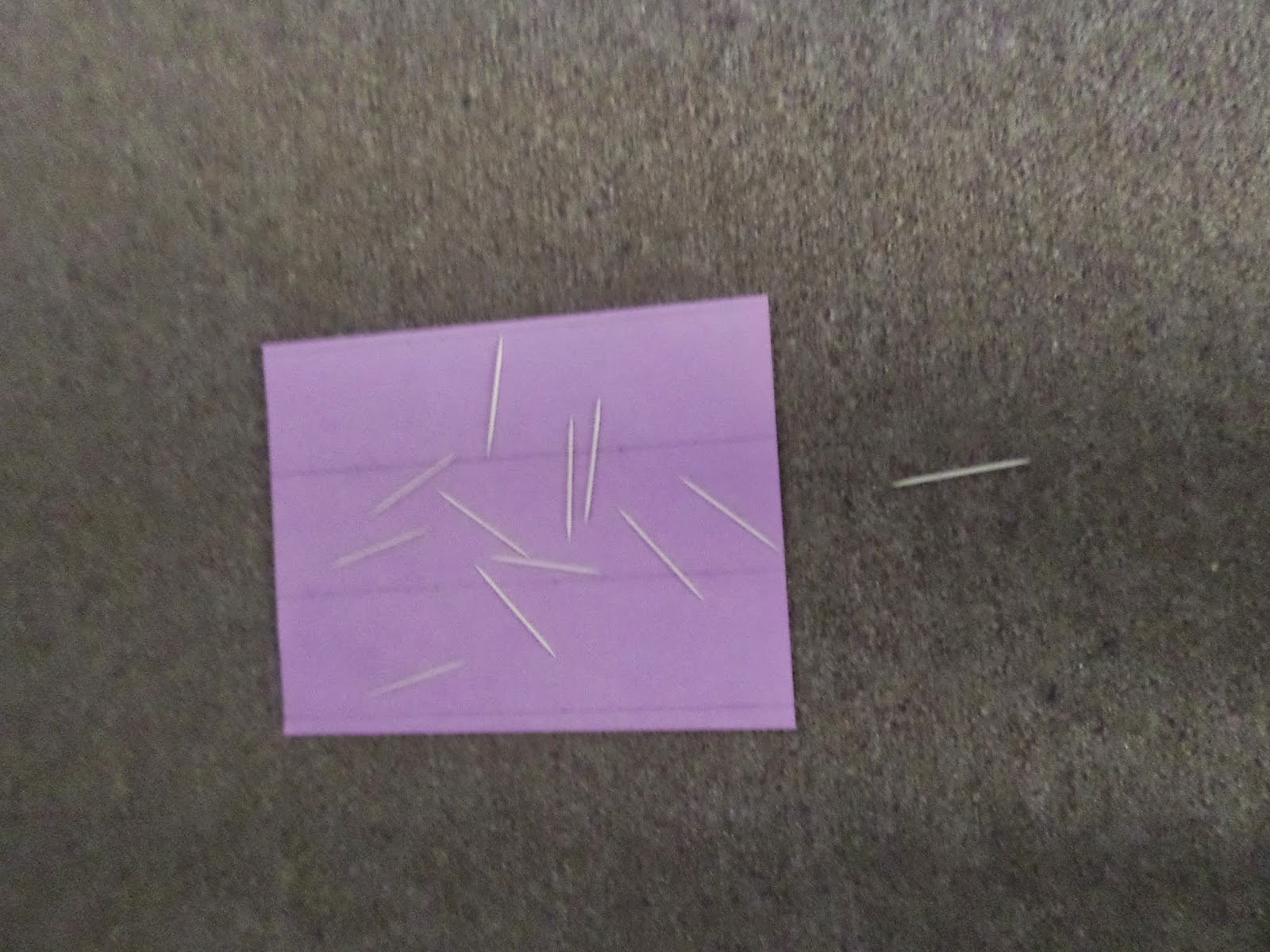 toothpicks tossed on colored paper. 