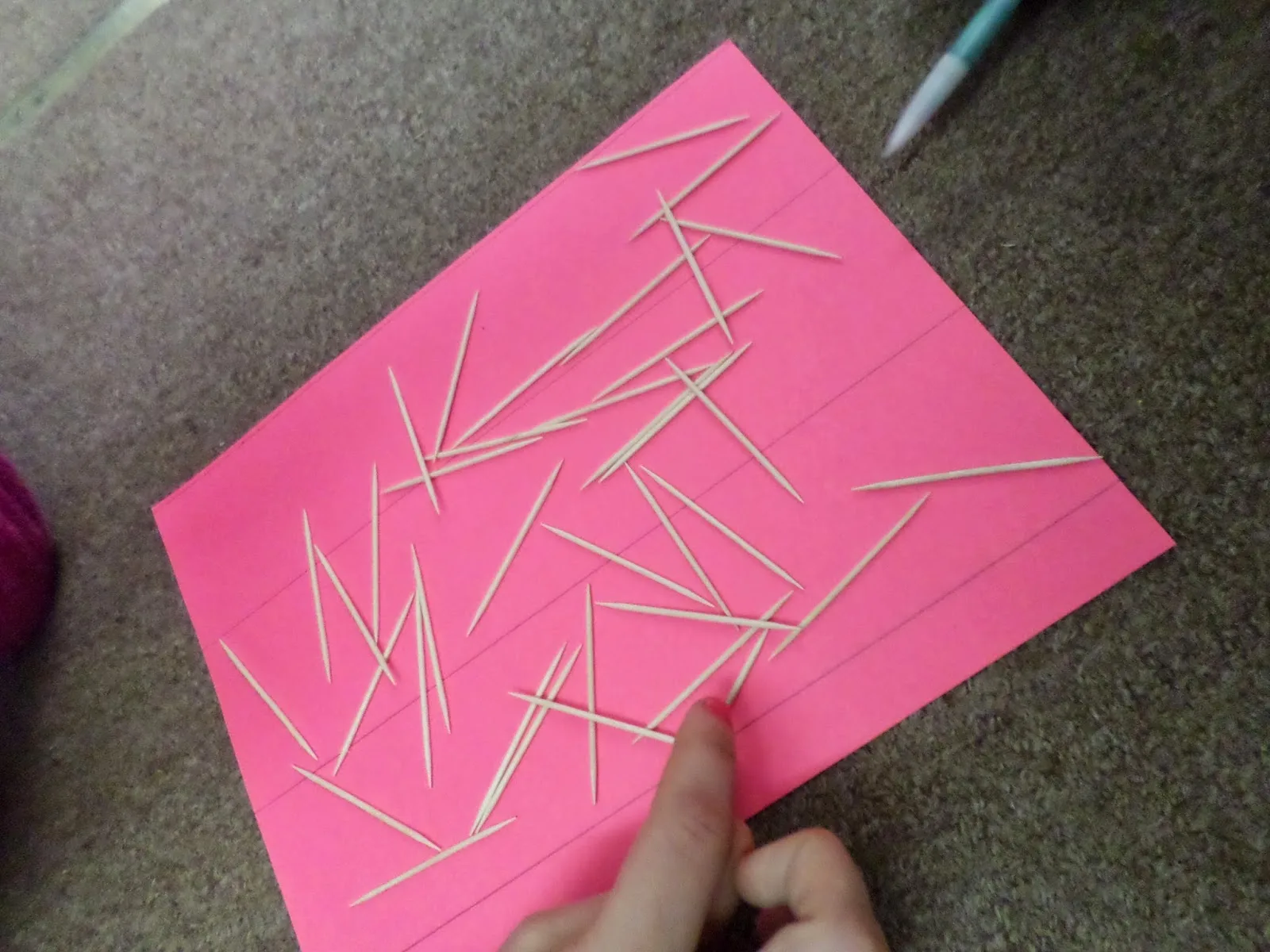 toothpicks tossed on colored paper. 