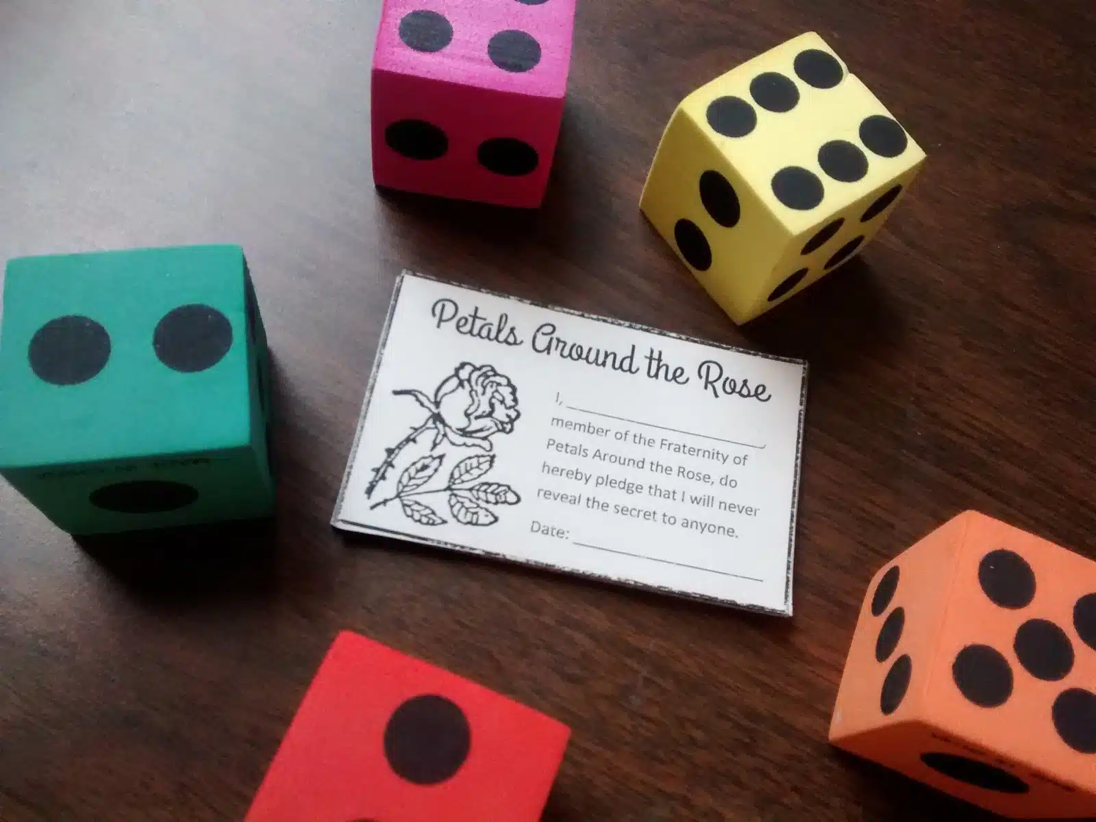 Petals around the rose membership card surrounded by foam dice. 