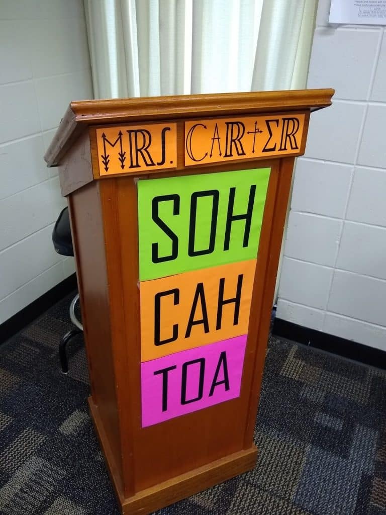 soh cah toa posters on podium in high school math classroom.