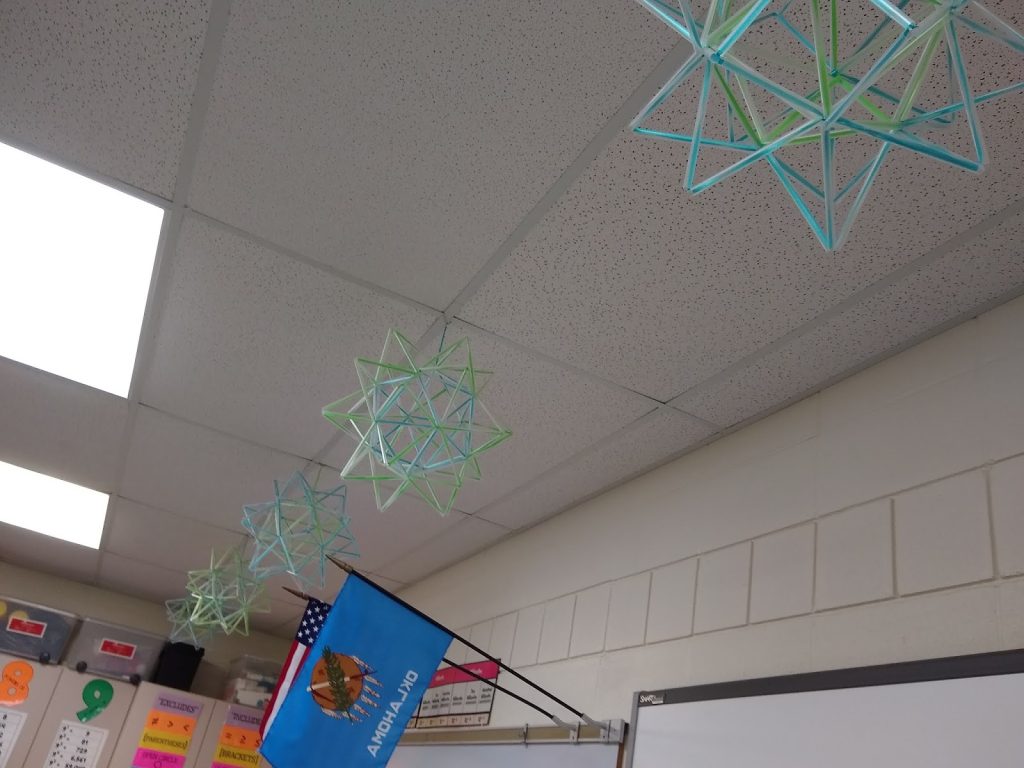 stellated icosahedron straw art hanging from ceiling in high school classroom. 