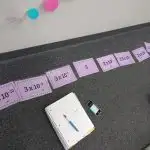 scientific notation ordering cards laying in row on floor of classroom.