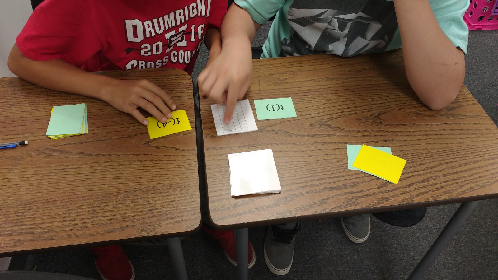 students pointing at card during evaluating functions activity war card game 