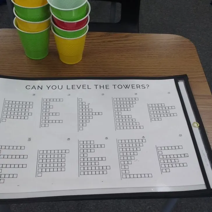 level the towers activity for introducing mean inside of dry erase pocket with text "can you level the towers?".
