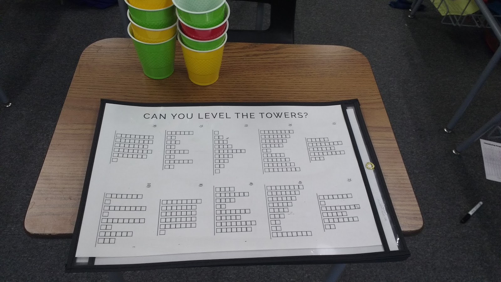 level the towers activity for introducing the concept of mean in dry erase pockets on desk in classroom. 