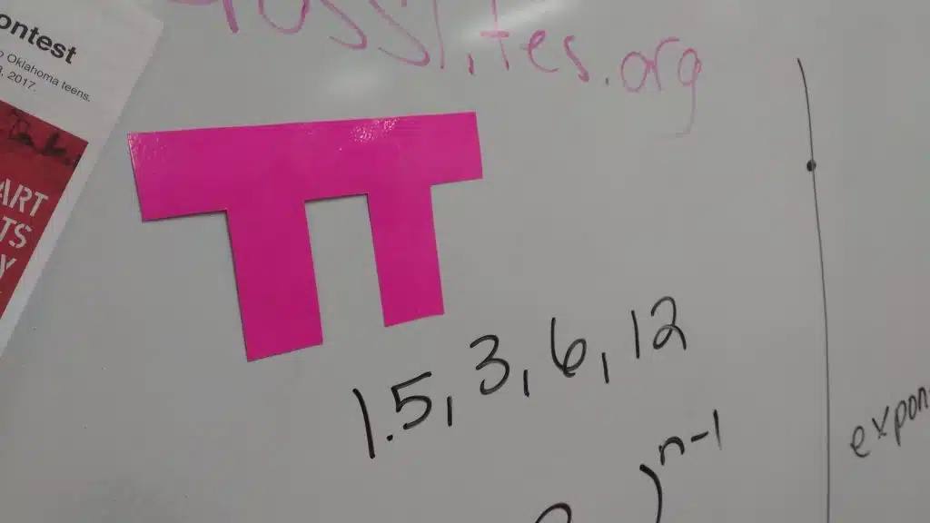 pi shape taped to dry erase board. 