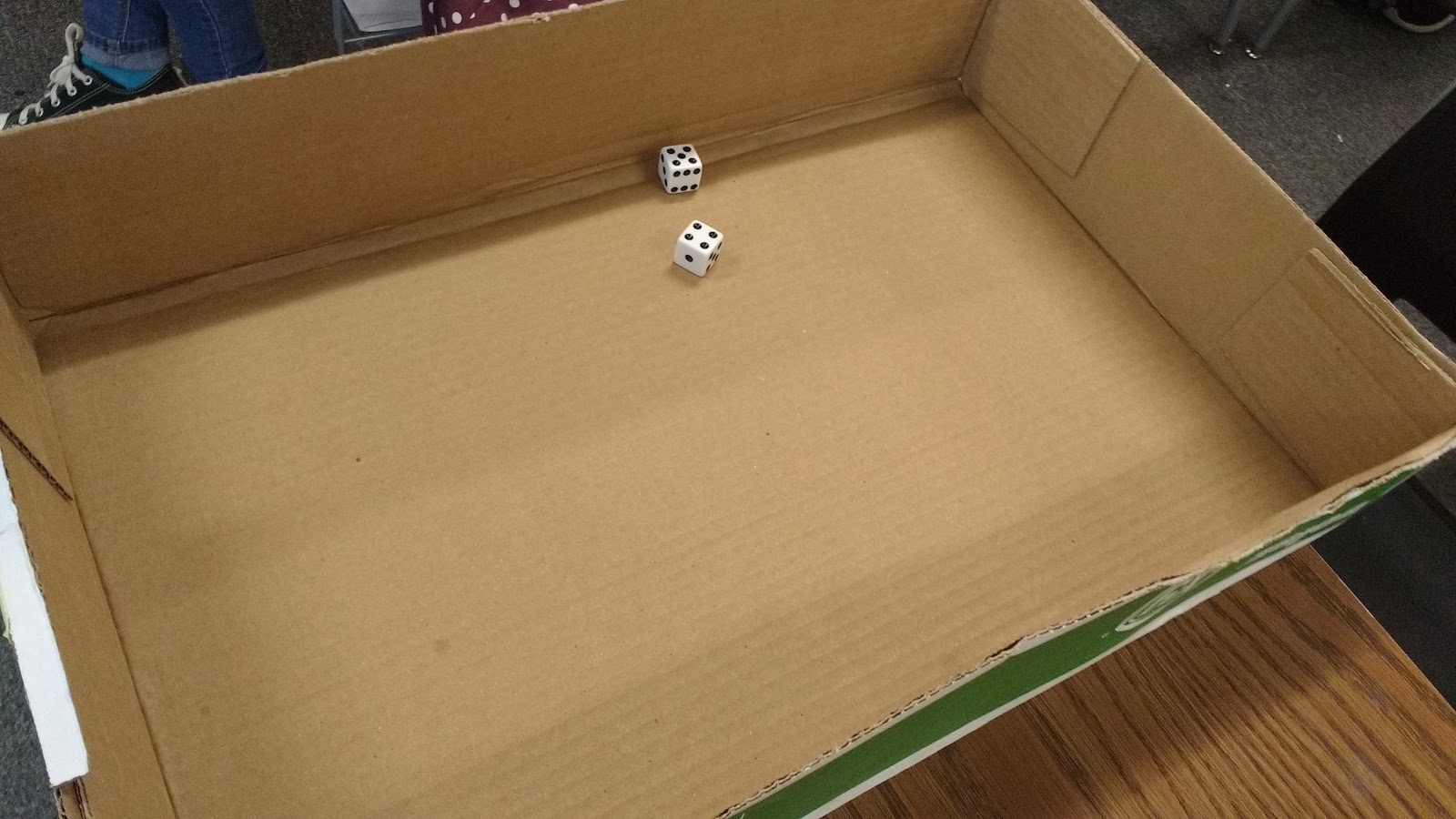 two dice in lid from copy paper box. 