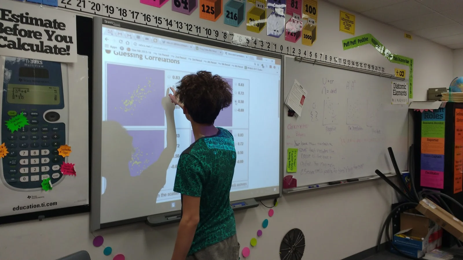 Student doing Istics Guessing Correlation Coefficient Game on smartboard. 