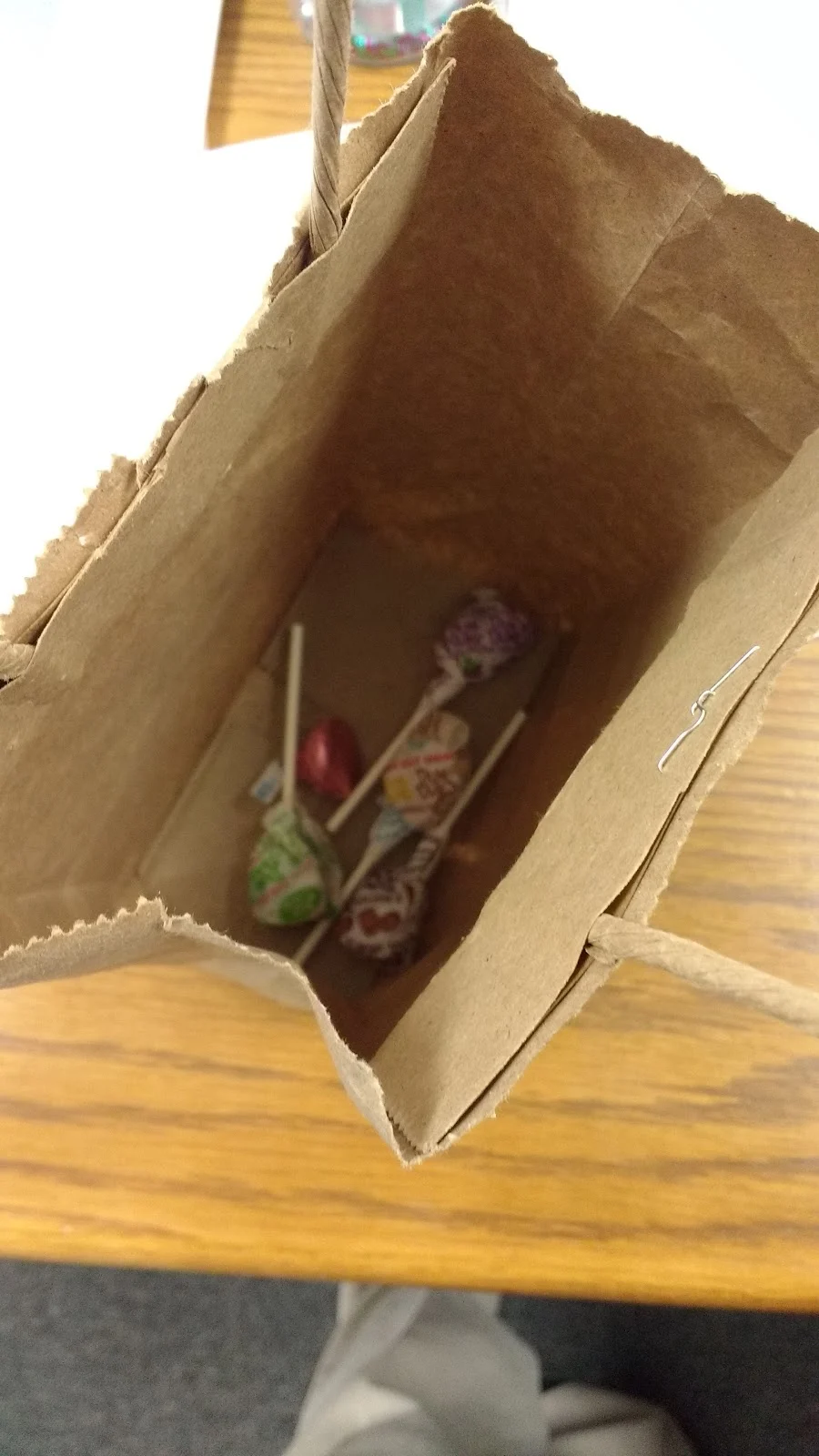 brown paper bag with candy inside. 