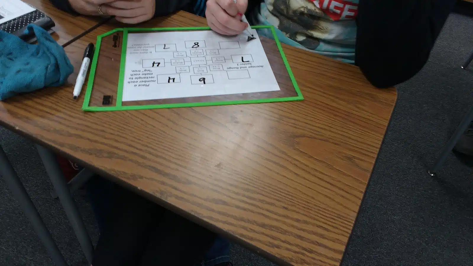 student working on mean, median, mode, and range spider puzzles