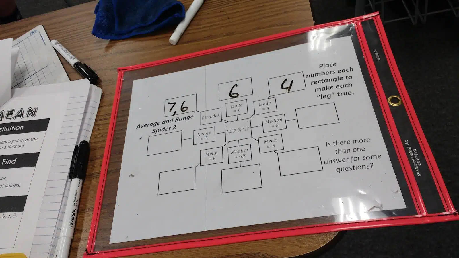 student working on mean, median, mode, and range spider puzzles