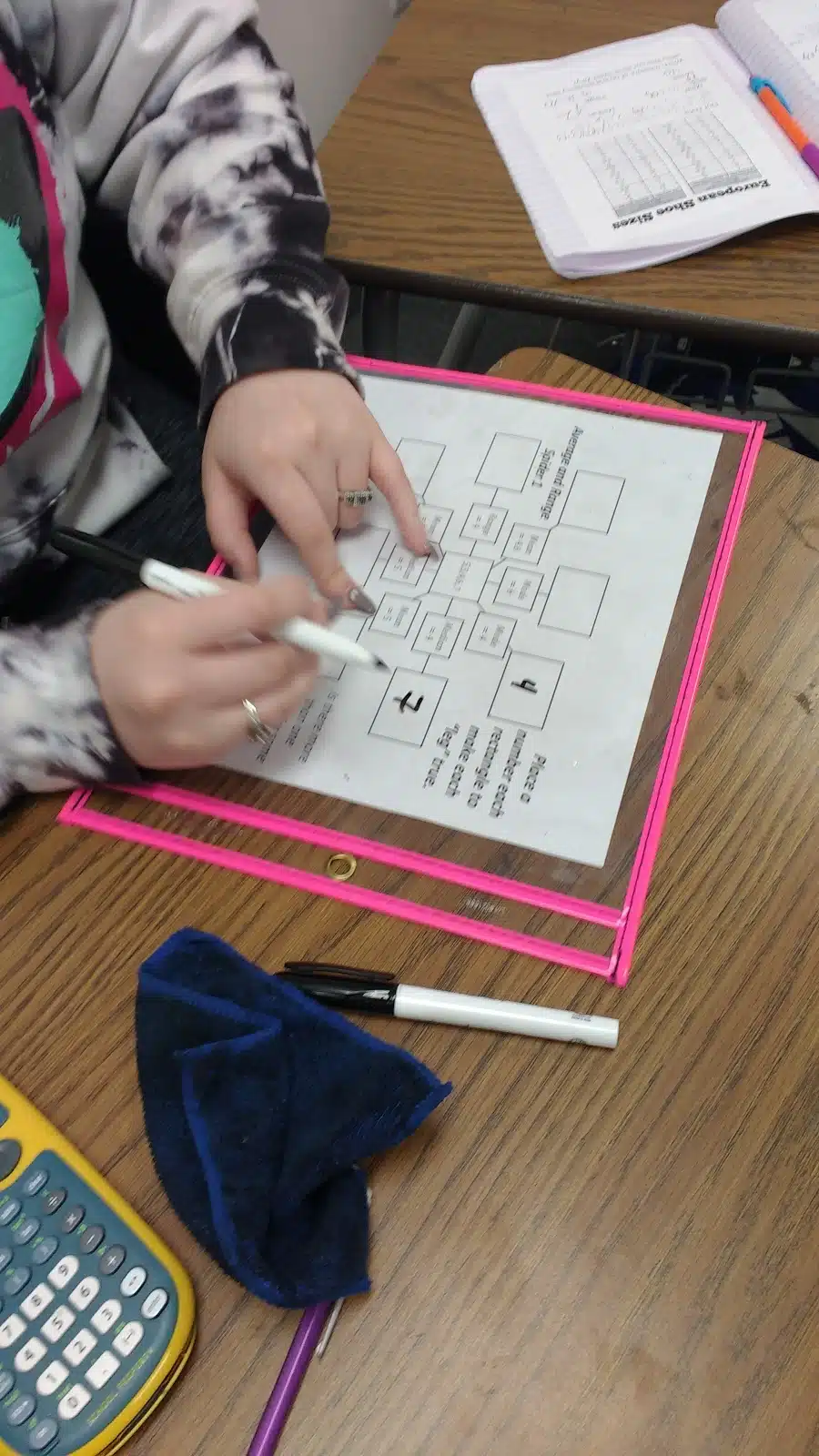 student working on mean, median, mode, and range spider puzzles