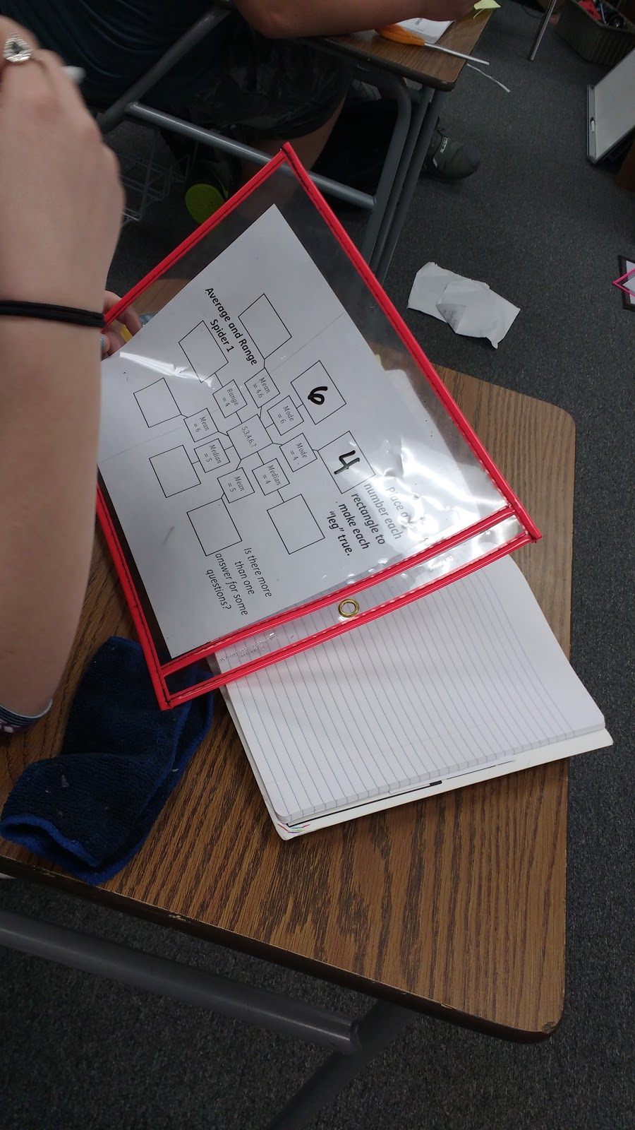 student working on mean, median, mode, and range spider puzzles