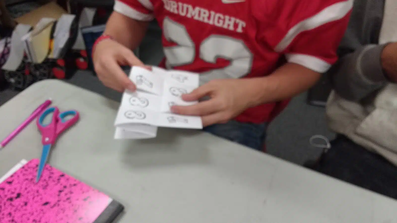 student working on crazy eight paper folding puzzle. 