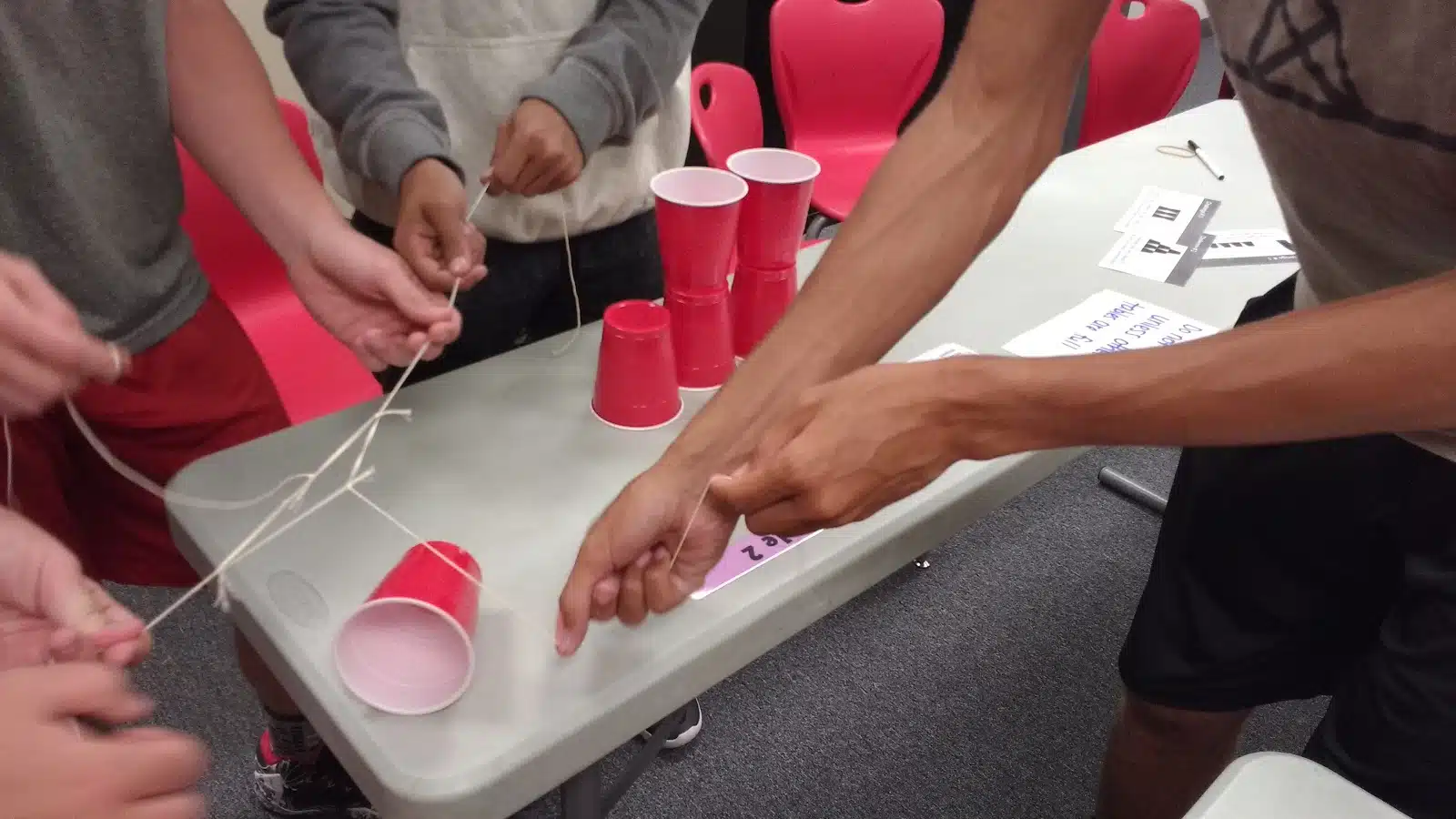 high school students participating in cup stacking challenge as a team building activity during the first week of school 