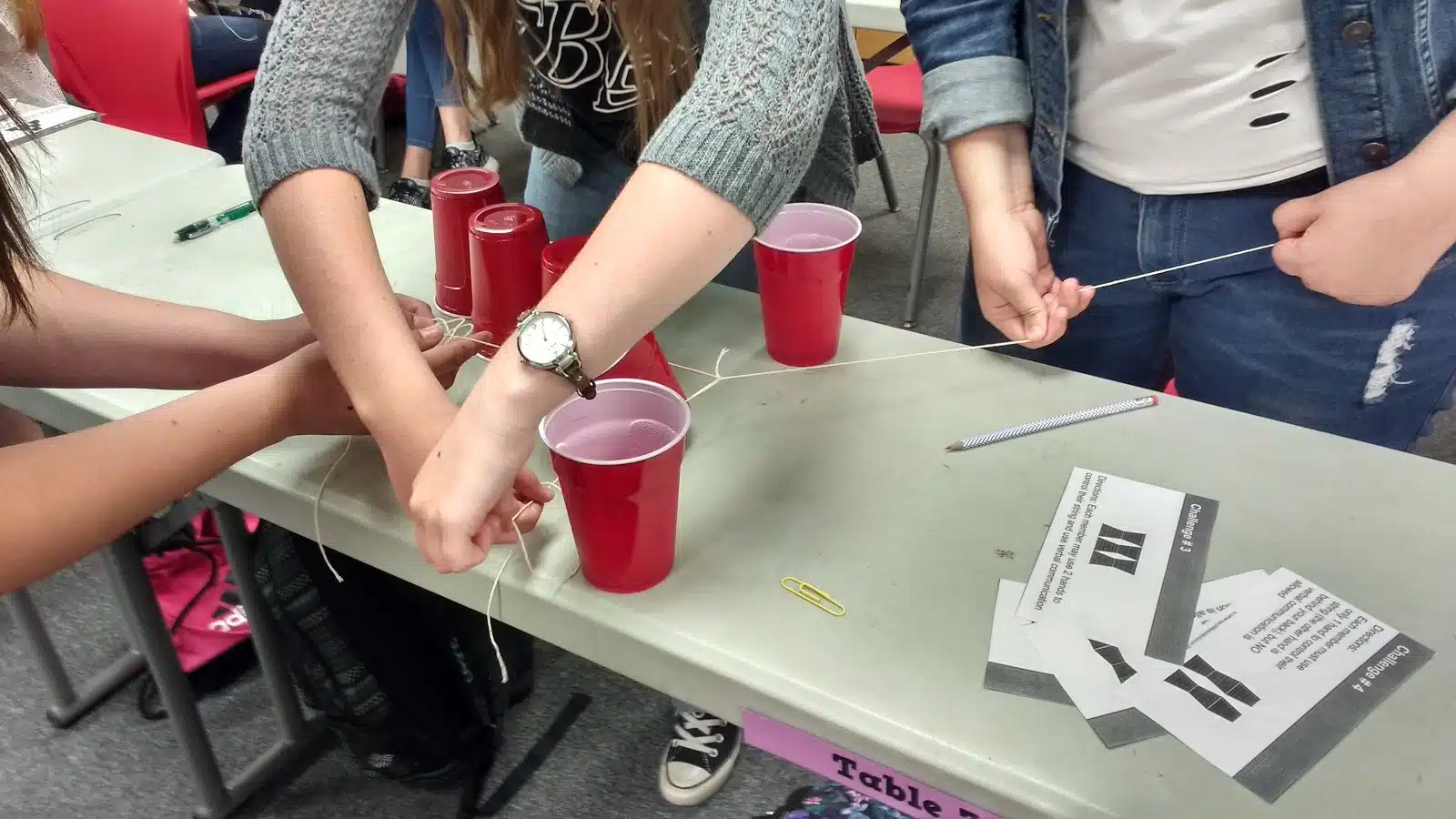 high school students participating in cup stacking challenge as a team building activity during the first week of school 