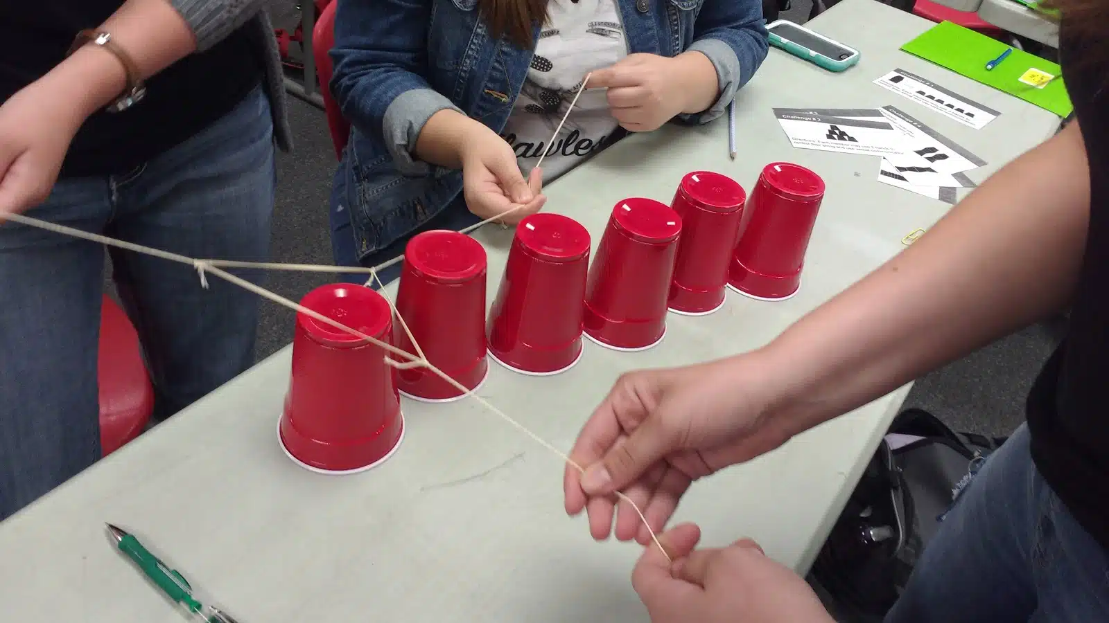 high school students participating in cup stacking challenge as a team building activity during the first week of school 