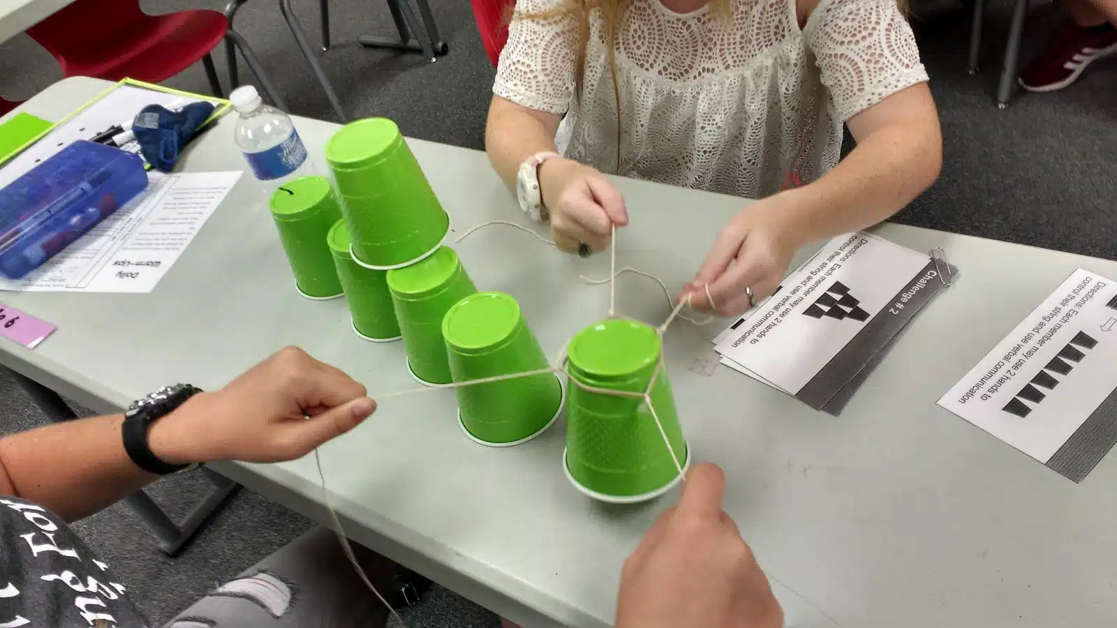 high school students participating in cup stacking challenge as a team building activity during the first week of school 