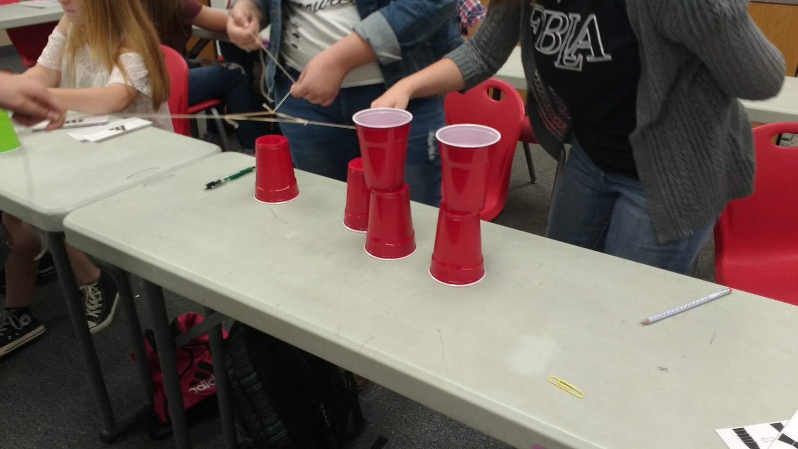 high school students participating in cup stacking challenge as a team building activity during the first week of school 