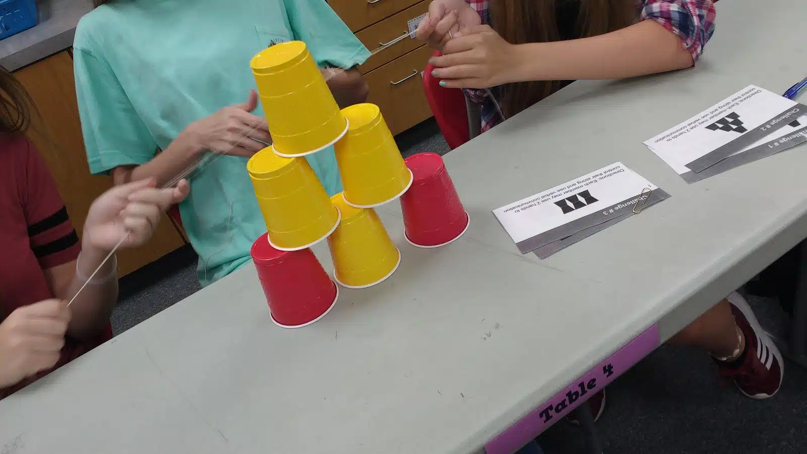 high school students participating in cup stacking challenge as a team building activity during the first week of school 