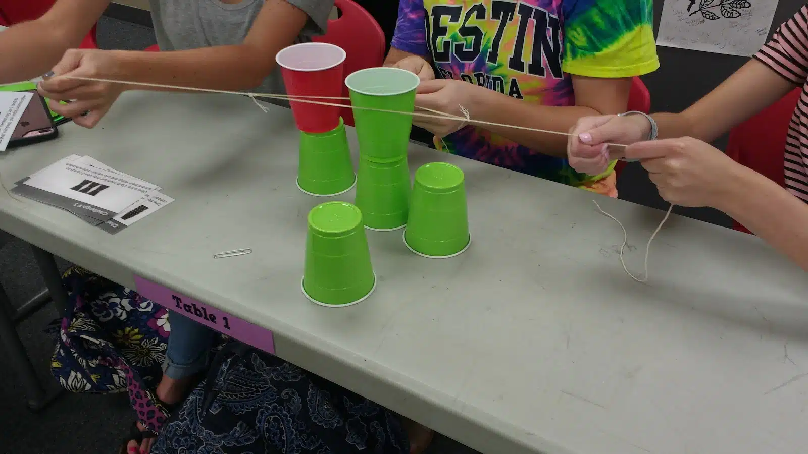 high school students participating in cup stacking challenge as a team building activity during the first week of school 