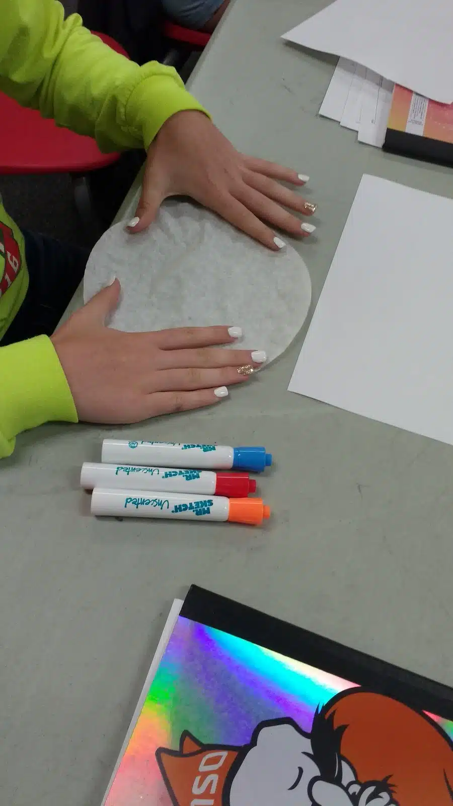 student spreading out coffee filter on desk. 