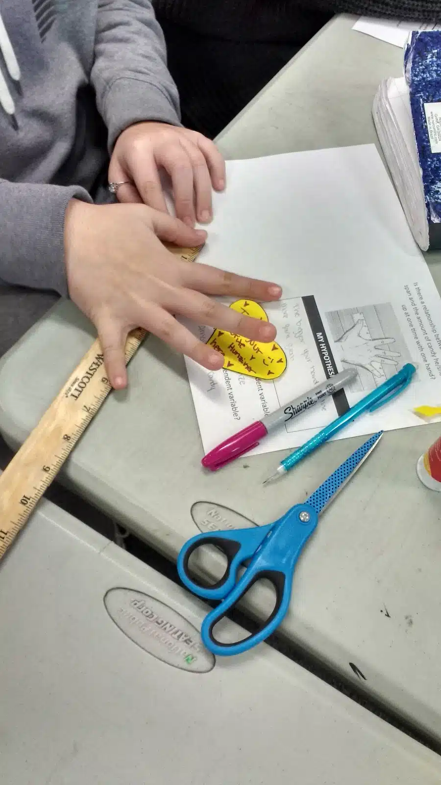 student measuring handspan for starburst scatterplot activity. 