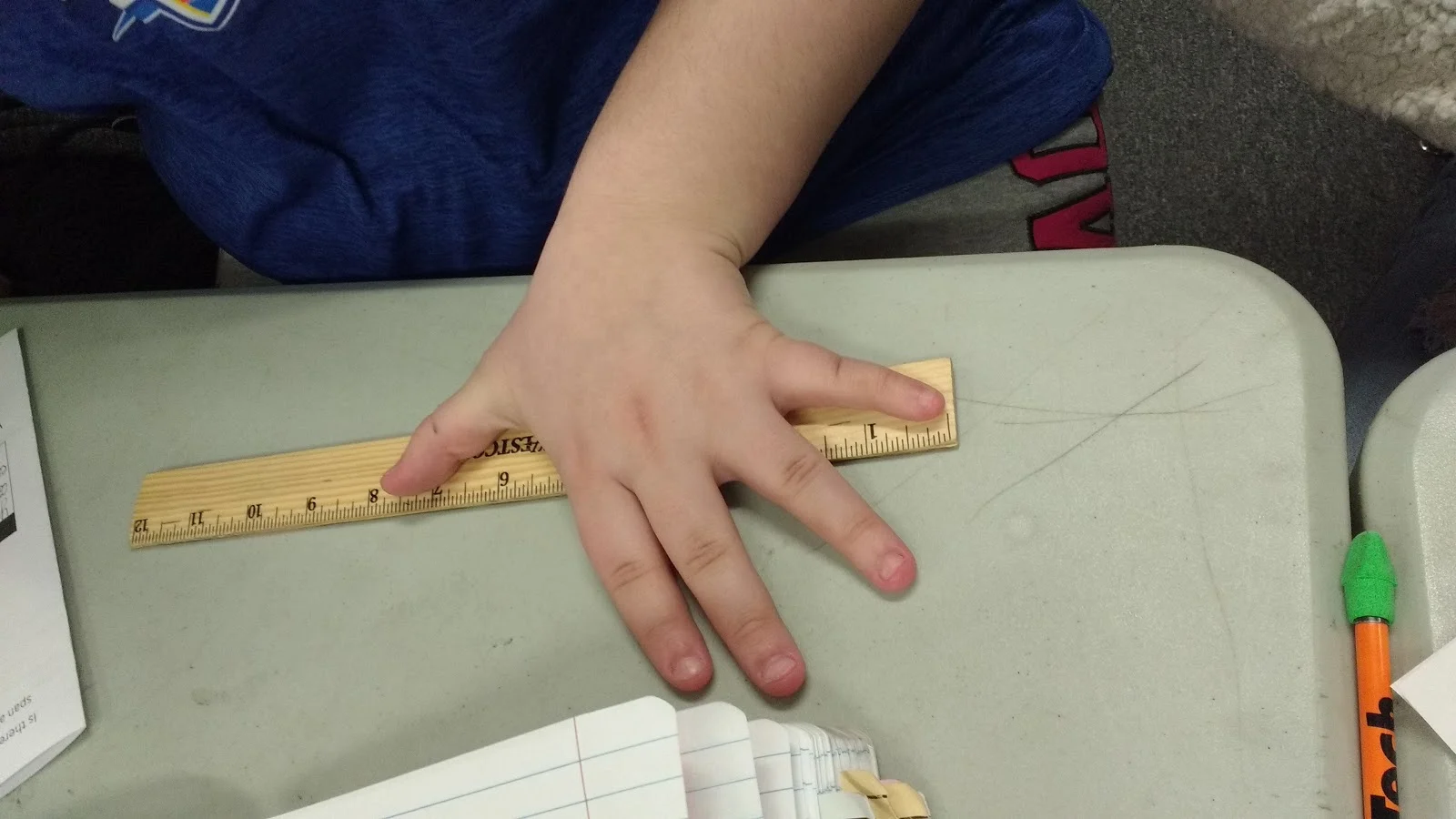 student measuring handspan for starburst scatterplot activity. 