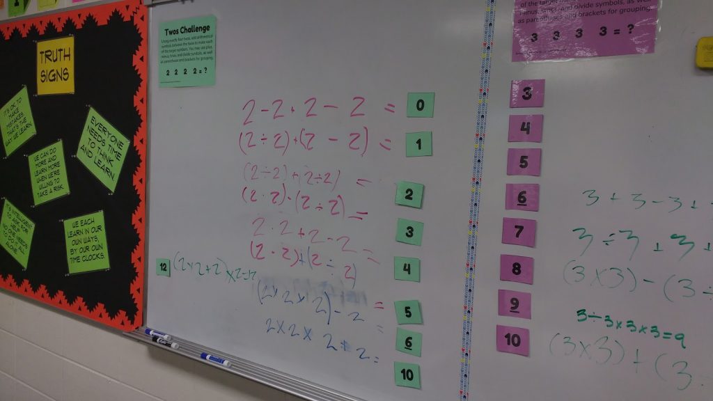 twos to nines number challenges posted on classroom dry erase board
