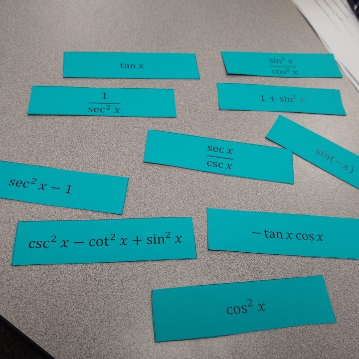 trig identities matching activity cards laying on desk in high school math classroom.