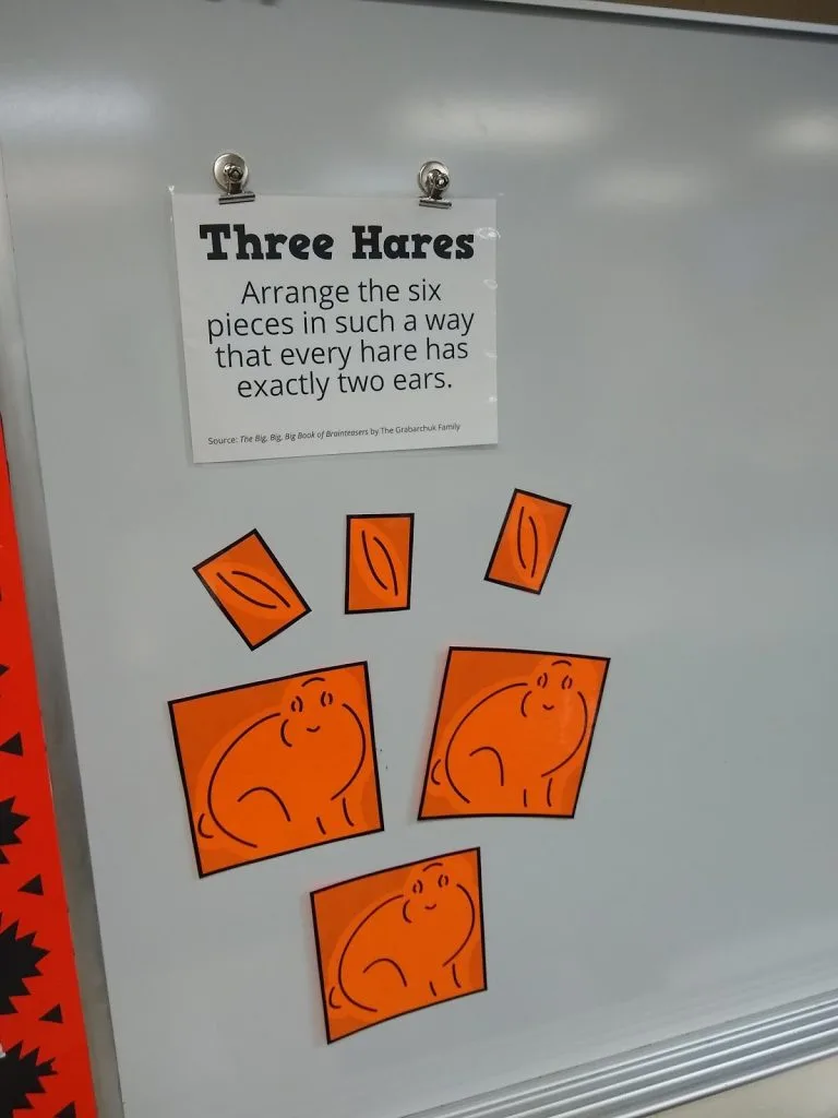 three hares puzzle on dry erase board. 