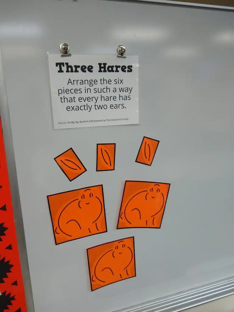 three hares puzzle on dry erase board. 