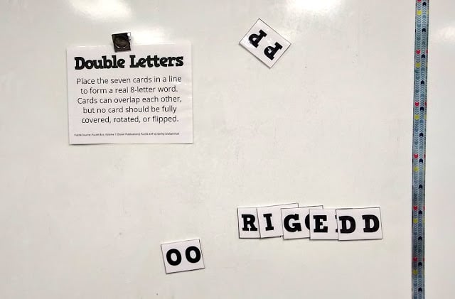 double letters puzzle partially solved on dry erase board. 