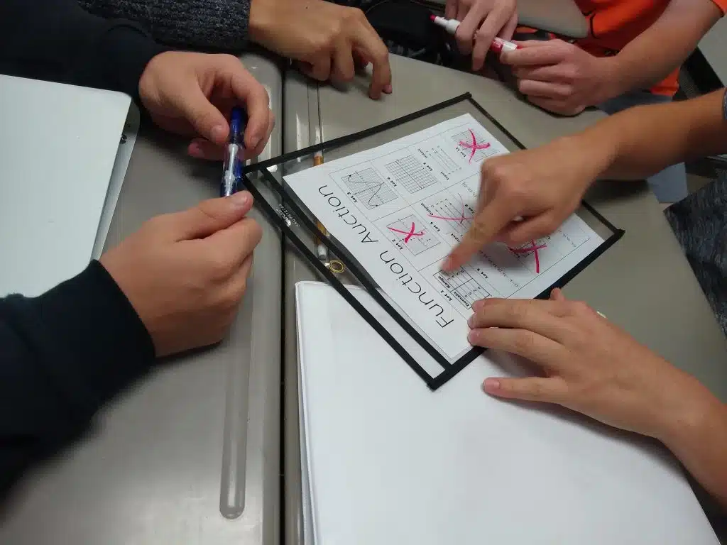 students pointing at function auction page. 