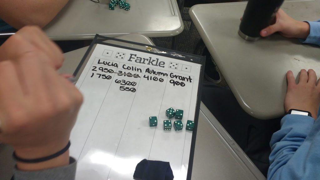 Students playing game of farkle with farkle score sheet. 