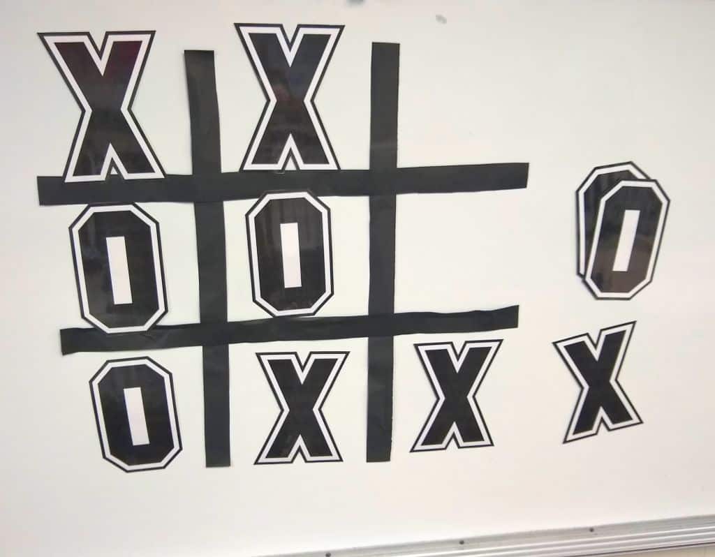 Jumbo tic tac toe game on dry erase board.