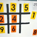 Numerical tic tac toe game on dry erase board.
