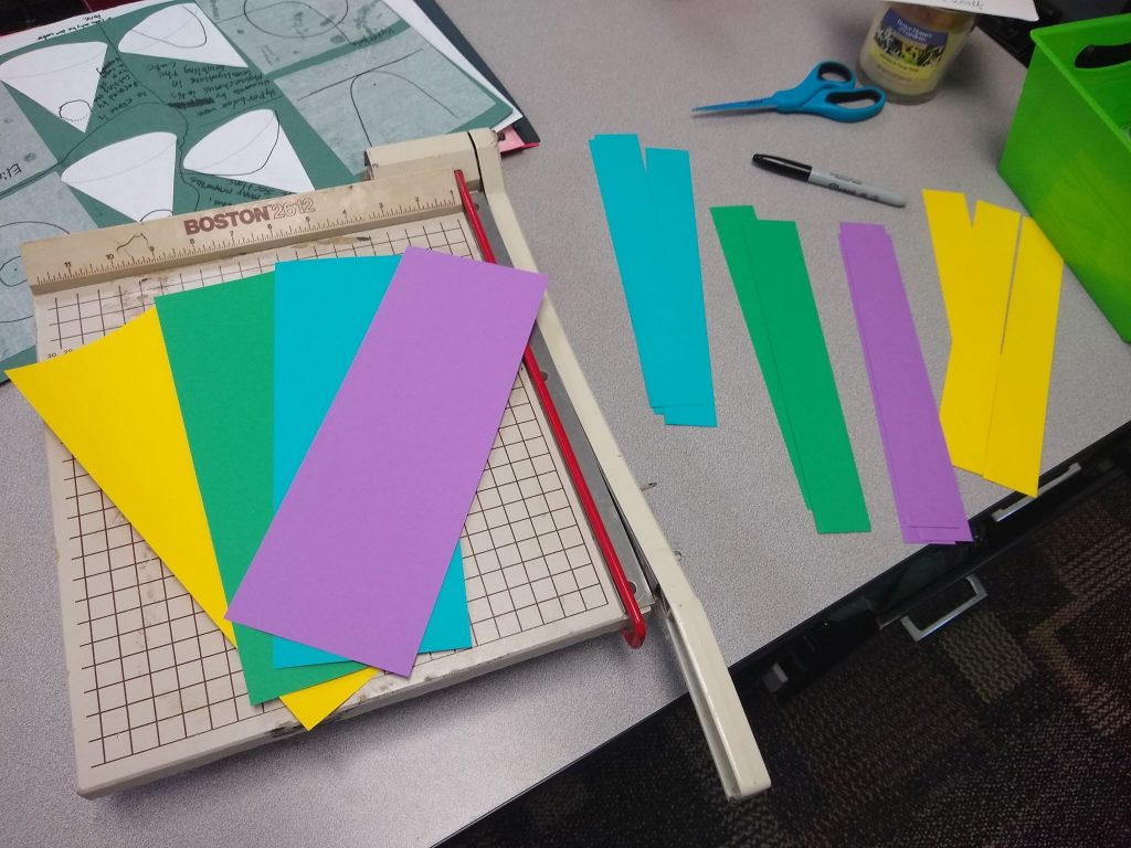 cutting paper strips for let's make squares activity. 