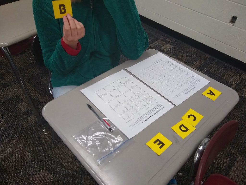Student holding up card for Exponent Rules Match-Up Activity