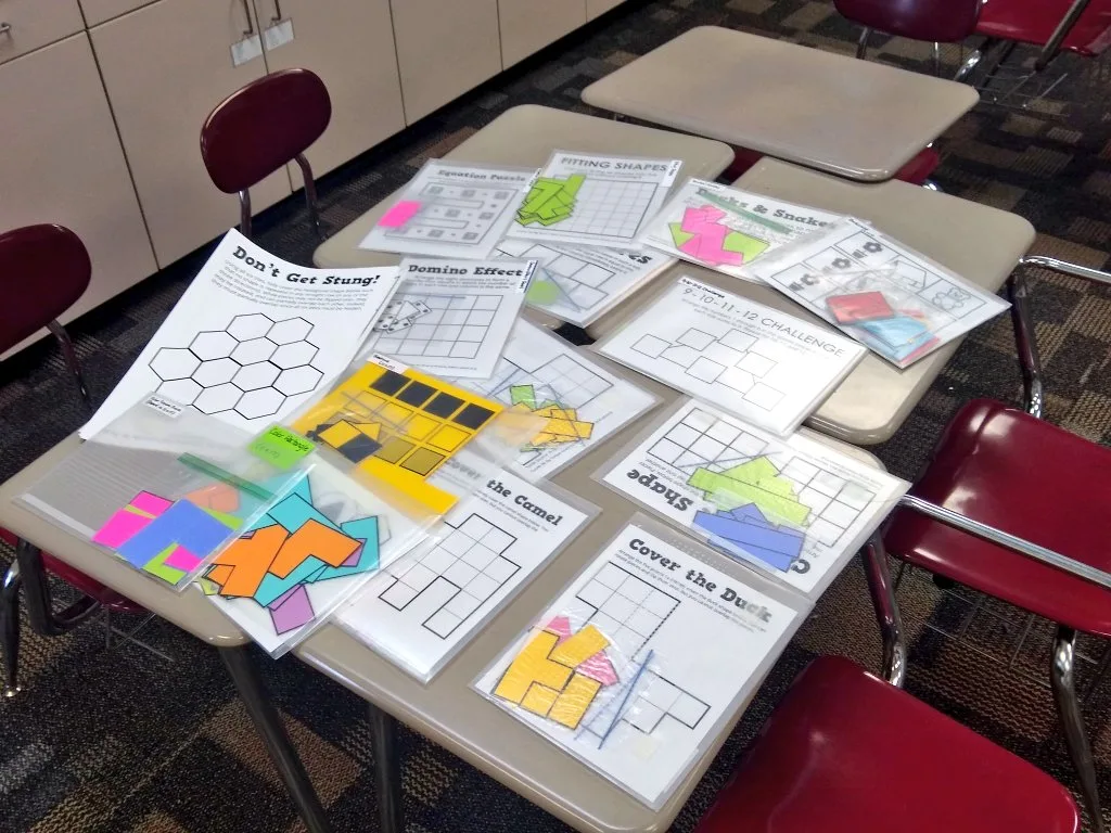 printed and laminated puzzles laying on desk in classroom. 