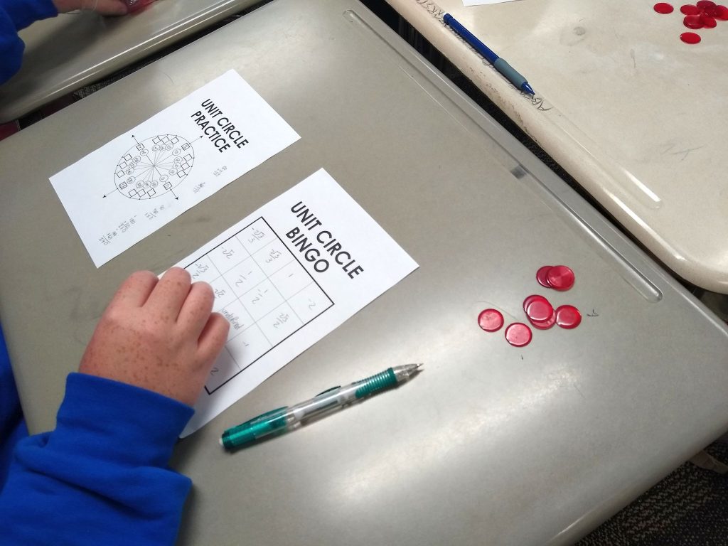 student placing bingo chip on bingo card 