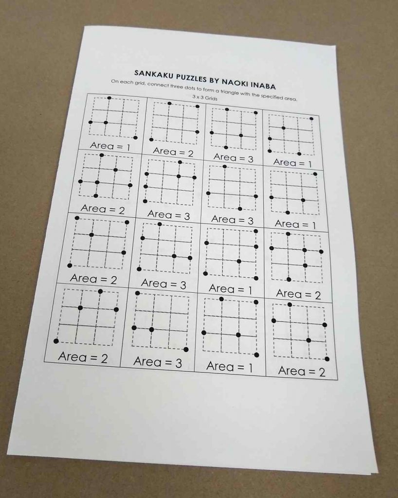 Piece of paper folded in half with sankaku puzzles printed on it 
