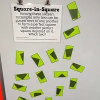 square in square puzzle hanging on dry erase board.