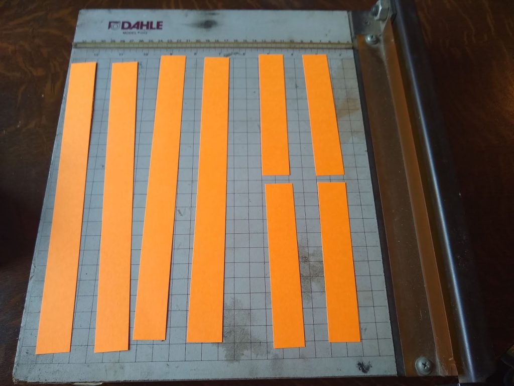 4 long strips of cardstock and 4 short strips of cardstock. 