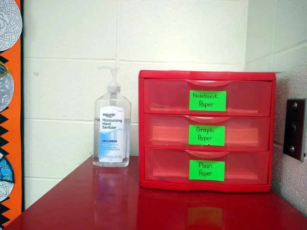three drawer organizer and bottle of hand sanitizer 